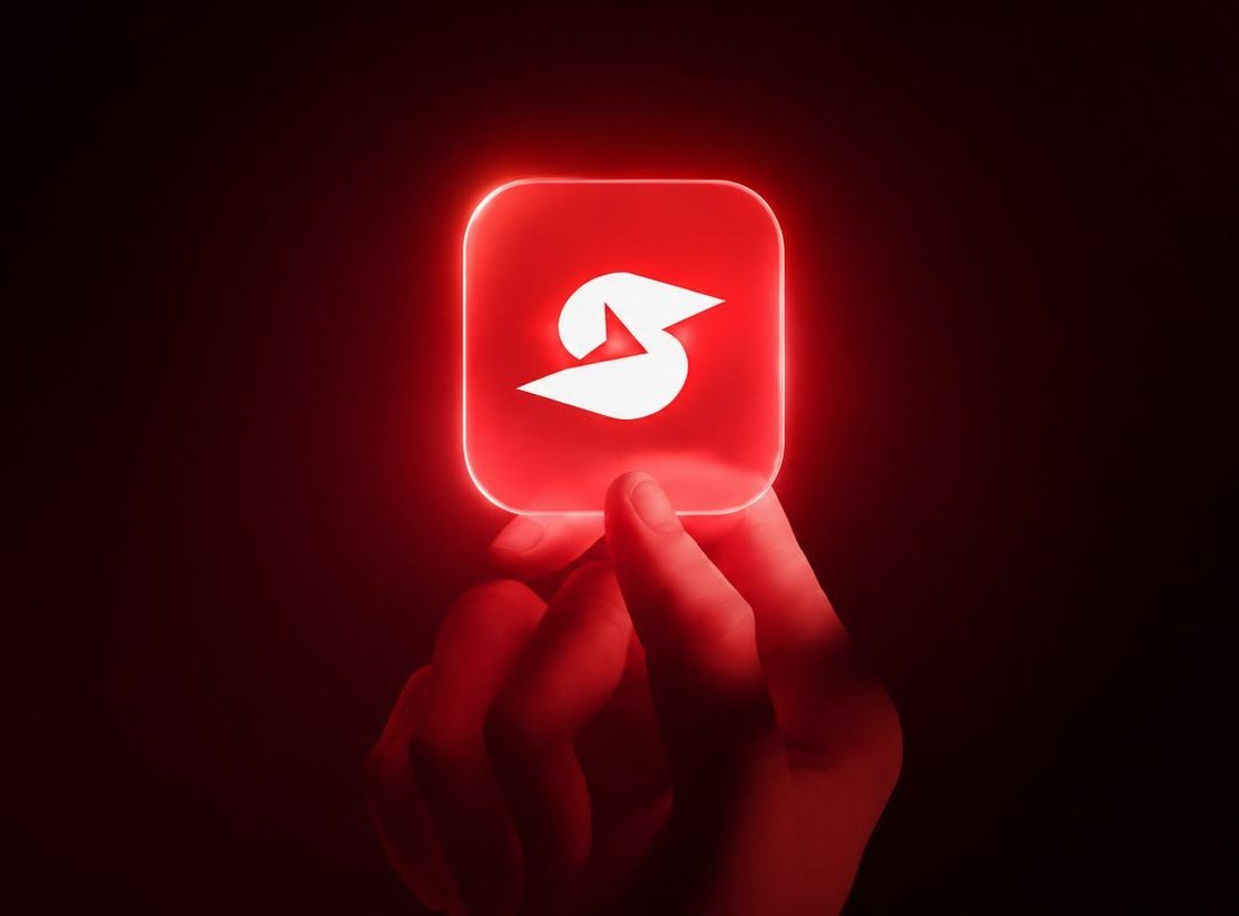 A hand holding the glowing red Ss Infoserve app icon